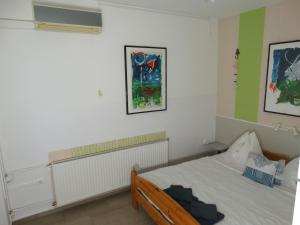 a small bedroom with a bed and a radiator at Aqua Ház Panzió 3 sz in Balatonfüred