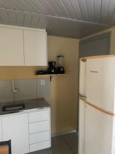 a kitchen with white cabinets and a refrigerator at Ap completo ótimo local próximo shopping 1 in Campo Grande