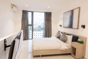 a bedroom with a bed and a large window at Skyline Loft, The Lennox in Accra