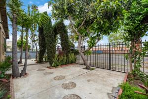 a wrought iron fence with trees and a sidewalk at The Avalon - Pre Summer Sale! 25 Percent Off May! in Los Angeles