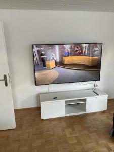 sala de estar con TV de pantalla plana en la pared en Ferienwohnung Weinbergglück en Lauda-Königshofen