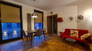 a living room with a red couch and a table at Studio M2 in Zamość