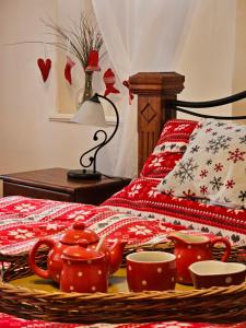 ein Bett mit roten Teekesseln und Tassen darauf in der Unterkunft Alfapartmány in Krásná Lípa