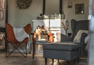 a living room with two chairs and a table at KisVulkán Nyúlontúl in Mencshely