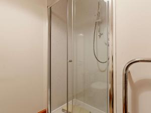 a shower with a glass door in a bathroom at 3 Bed in The Cairngorms IN515 in Laggan