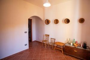 een woonkamer met een tafel en stoelen en een muur bij Omero in Tindari