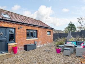 a garden with a brick house with a patio at 2 Bed in Stibbard 79993 