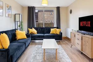 uma sala de estar com um sofá azul e uma televisão em Professionals,Contractors,Family em Leicester
