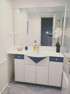 La salle de bains blanche est pourvue d'un lavabo et d'un miroir. dans l'établissement Apartamento centro Vitoria, à Vitoria-Gasteiz