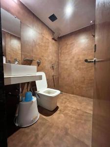 La salle de bains est pourvue de toilettes blanches et d'un lavabo. dans l'établissement Hotel the pacific Chakala, à Mumbai