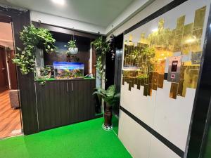 um quarto com um piso verde e uma porta com plantas em Hotel the pacific Chakala em Mumbai