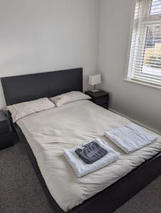 a bed in a bedroom with two towels on it at Modern 3 bedroom home, close to City Centre and Peak District in Heeley