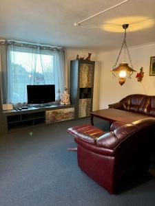 - un salon avec un canapé en cuir et une télévision dans l'établissement Lilla Röda Huset., à Sjötofta
