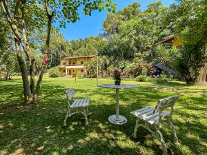 two chairs and a table in a yard at HOTEL POUSADA PARAÍSO in Itapevy