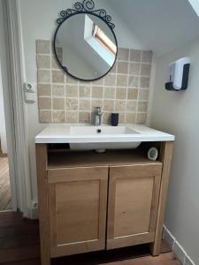 ein Bad mit einem Waschbecken und einem Spiegel in der Unterkunft Appartement 3 Pièces Bord de mer Place du 6 Juin in Arromanches-les-Bains