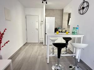 una cucina con tavolo bianco e 2 sgabelli di Apartamento moderno Centro de Marbella a Marbella