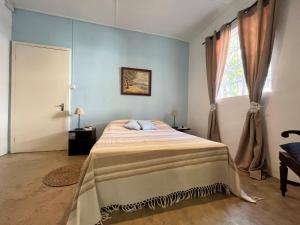 a bedroom with a bed and a window at La Case Creole in Roches Noires