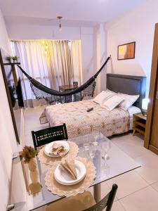 Ap standard confort bem localizado في كامبينا غراندي: غرفة بسرير وطاولة مع صحون وكاسات