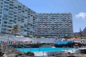 a large apartment building with a swimming pool and a hotel at D espacios elevados 1 in Punta del Hidalgo
