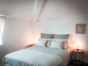 um quarto com uma cama com lençóis e almofadas azuis em Villa Ines em Riva del Garda