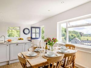 a kitchen with a wooden table with chairs and a window at 3 Bed in Ashford In The Water 88675 in Great Longstone