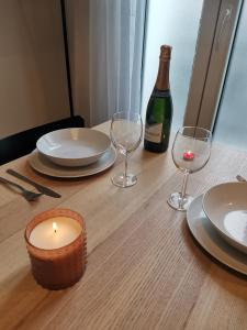a table with a candle and a bottle of wine at *Appartement Moderne/2 minutes du métro* in Saint-Ouen