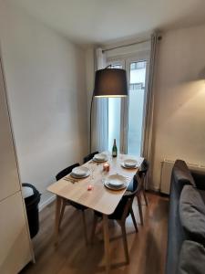 a table with plates and a lamp in a living room at *Appartement Moderne/2 minutes du métro* in Saint-Ouen