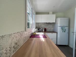 a kitchen with a wooden counter top and a refrigerator at Studio à 10 minutes de l'océan in Saint-André-de-Seignanx +5 photos