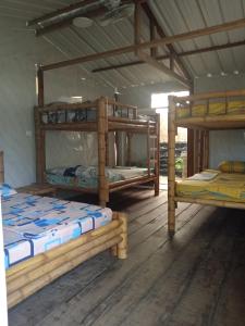 two bunk beds in a room with wooden floors at Los cocos Hostal in Bazán