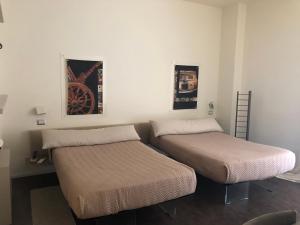 dwa łóżka siedzące obok siebie w pokoju w obiekcie Cinquecento B&B w mieście Barcellona-Pozzo di Gotto