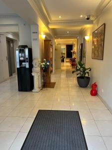 a lobby with a black refrigerator and a tile floor at 121 Paris Hotel in Paris