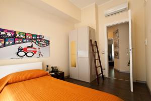una camera con un letto arancione e una scala di Cinquecento B&B a Barcellona Pozzo di Gotto