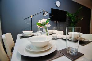 una mesa con un tazón blanco y platos y vasos en 2 bed flat in Islington en Londres