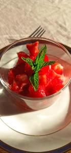 a bowl of red fruit with a green leaf on a plate at LE BONHEUR DES HÔTES in Suèvres +11 photos