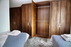 a bedroom with two beds and wooden cabinets at 2 bed flat in Islington in London