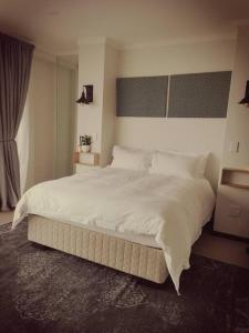 a bedroom with a large bed with white sheets at Beachfront Townhouse - MowenOne in Walvis Bay