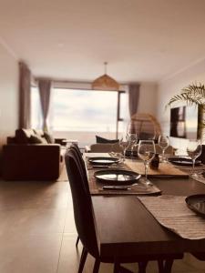uma sala de jantar com uma mesa com copos de vinho em Beachfront Townhouse - MowenOne em Walvis Bay
