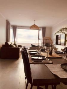 a dining room with a table with wine glasses at Beachfront Townhouse - MowenOne in Walvis Bay +7 photos