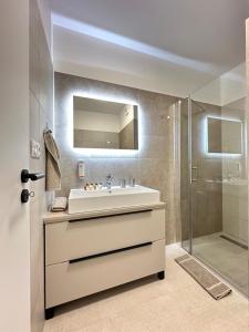 a bathroom with a sink and a shower at Trendy Apartment in Trenčín
