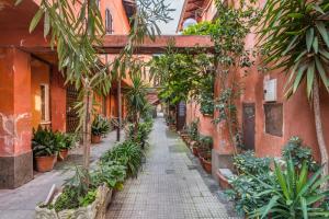 an alley in an old building with potted plants at FAMM Apartments - Charming open space in Trastevere in Rome