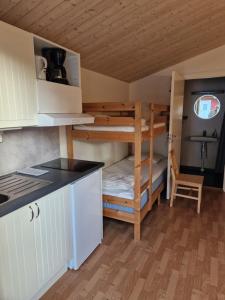 małą kuchnię z łóżkiem piętrowym w małym domku w obiekcie Lovsjöbadens Camping w mieście Jönköping