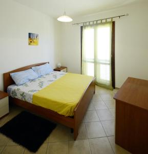 馬里內拉迪塞利的住宿－Antonella houses，一间卧室配有一张黄色毯子床
