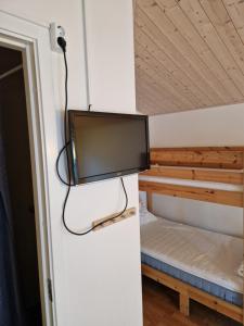 a flat screen tv hanging from a wall in a room at Lovsjöbadens Camping in Jönköping