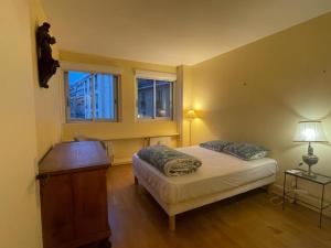 una camera con un letto e un tavolo e due finestre di Double room in Beautiful apartment a Parigi