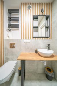 een badkamer met een wastafel, een spiegel en een bad bij Stylowy apartament Blue ~self check in 24h in Wrocław