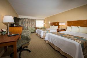 オガンキットにあるGorges Grant Hotelのベッド2台とデスクが備わるホテルルームです。