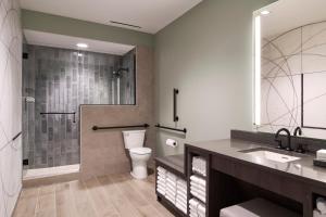 a bathroom with a toilet and a shower and a sink at Loews Nashville Hotel at Vanderbilt Plaza in Nashville