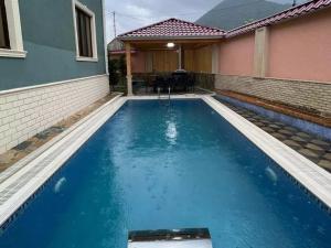 uma piscina numa casa com água azul em Green villa em Gabala