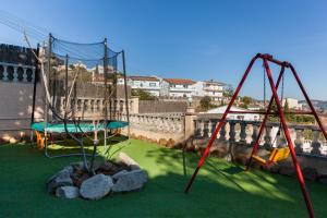 a playground with two swings and rocks in a yard at Villa Sol in Sant Cebrià de Vallalta