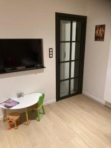 ニーウポールトにあるChristinaのテーブルとテレビのあるリビングルーム